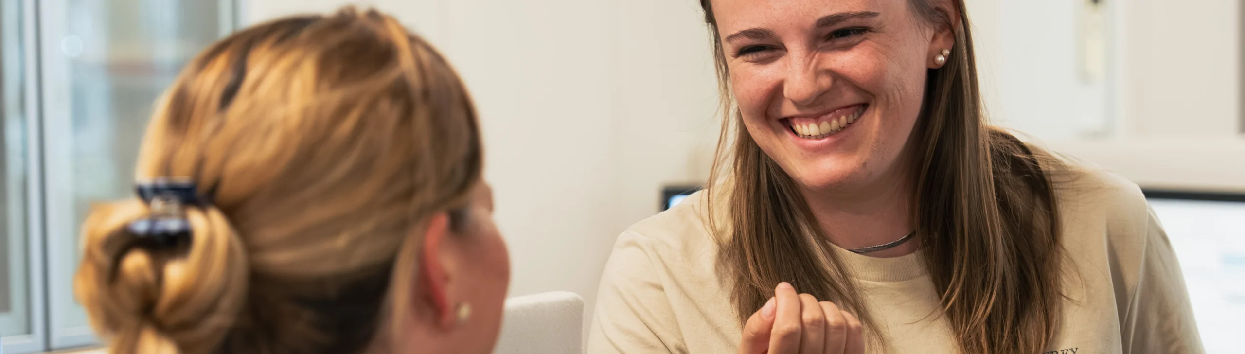 Zwei Mitarbeiterinnen der Rechtsanwaltskanzlei freuen sich über den guten Ausgang eines Falls einer Mandantin