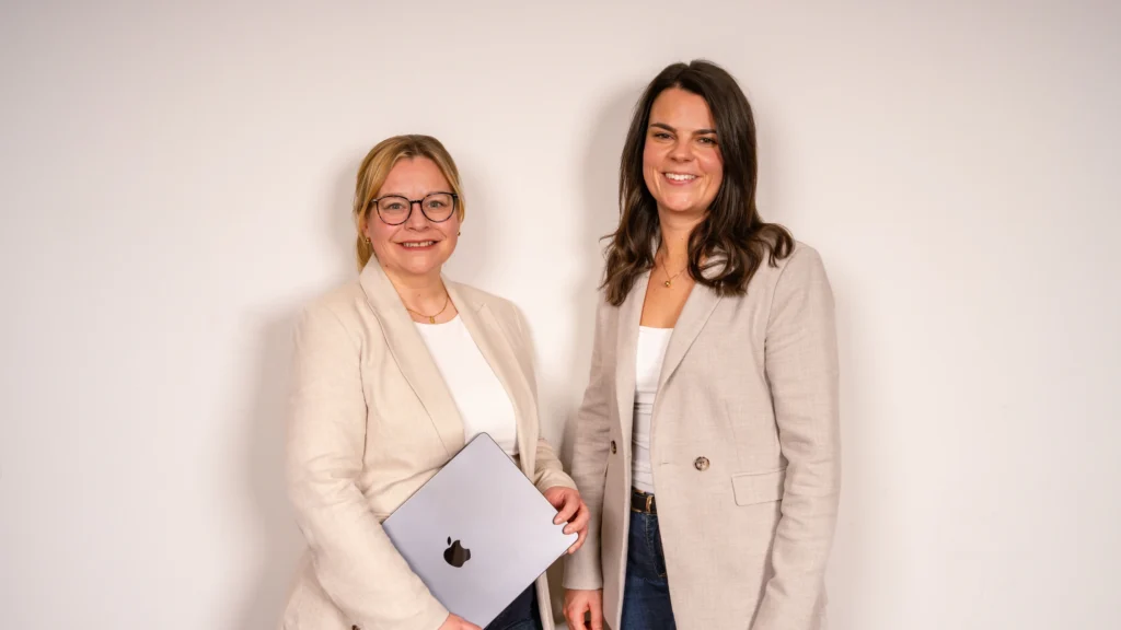 Die Anwältinnen für Verkehrsrecht Nina Schnabel und Julia Witthüser der Kanzlei Meyer & Frey aus Würzburg lächeln freundlich.